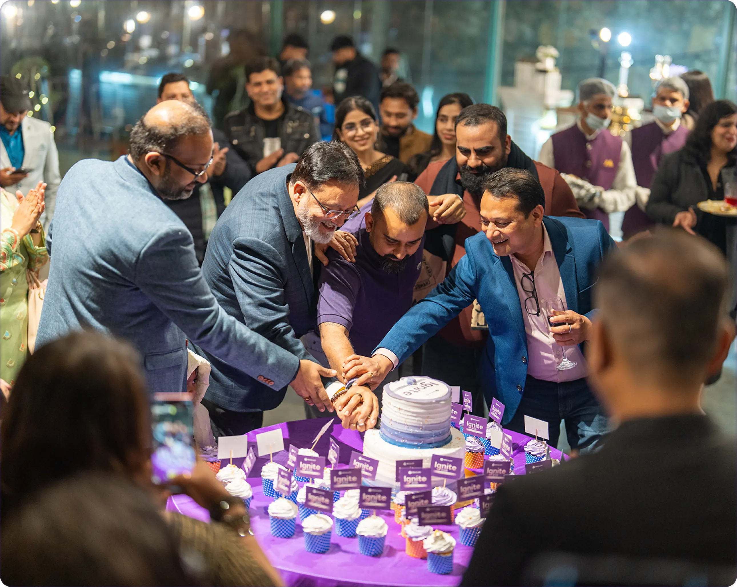 Hexalog's founders cutting the anniversary cake, surrounded by the team