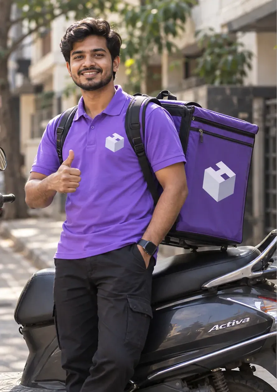 A Hexalog delivery associate handing a parcel to a neighbourhood store owner